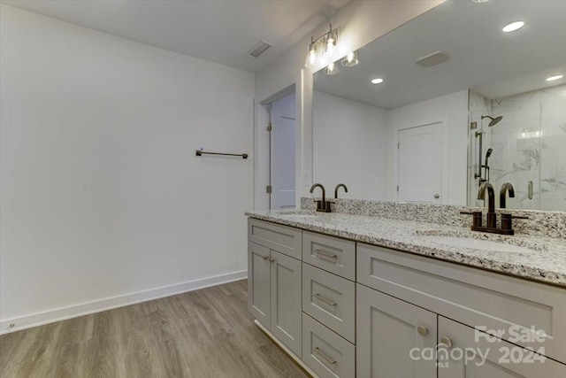 bathroom featuring hardwood / wood-style floors, vanity, and a shower with shower door