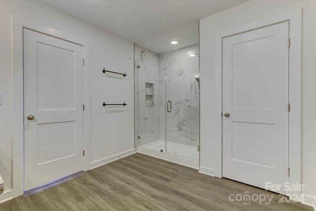 bathroom featuring an enclosed shower and wood-type flooring