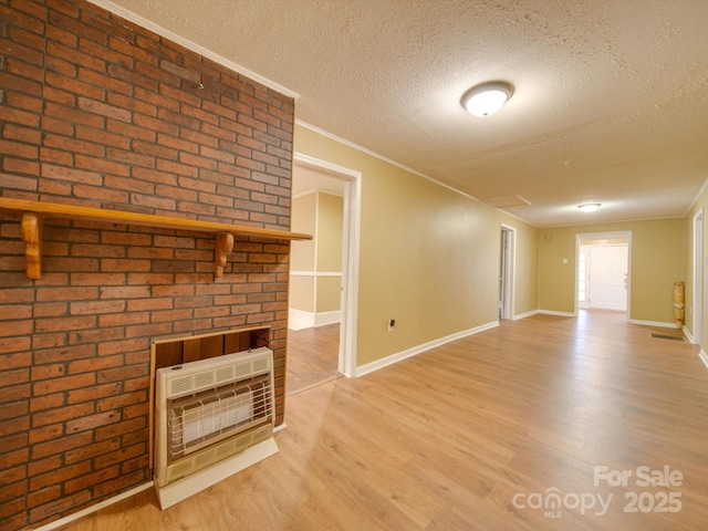 unfurnished living room featuring heating unit, crown molding, hardwood / wood-style floors, and a textured ceiling