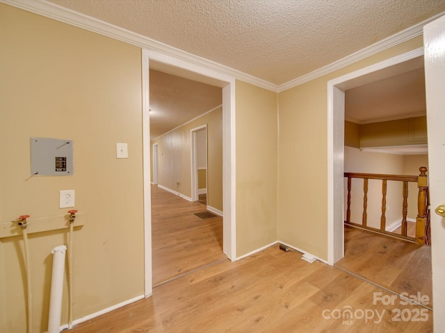 corridor featuring a textured ceiling, hardwood / wood-style flooring, and ornamental molding