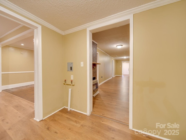 hall with crown molding, a textured ceiling, and hardwood / wood-style flooring