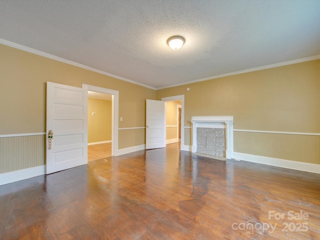 spare room with a textured ceiling, hardwood / wood-style flooring, and crown molding