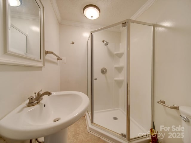 bathroom featuring crown molding, an enclosed shower, and sink