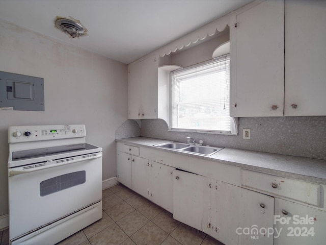 kitchen with white electric range, sink, light tile patterned floors, tasteful backsplash, and white cabinetry