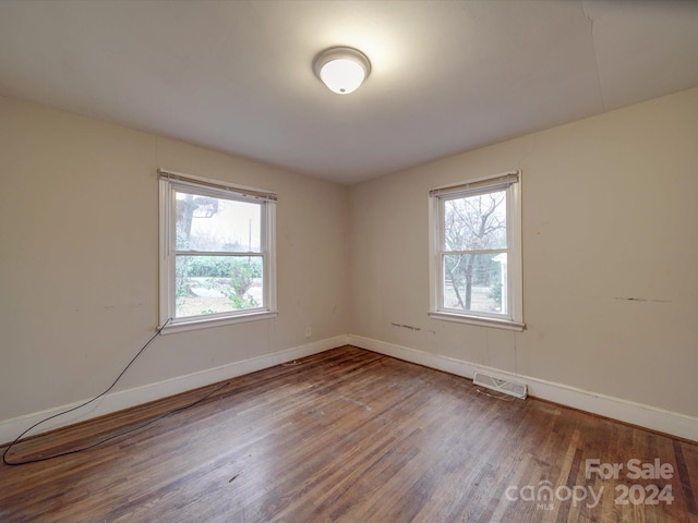 spare room featuring a healthy amount of sunlight and hardwood / wood-style flooring