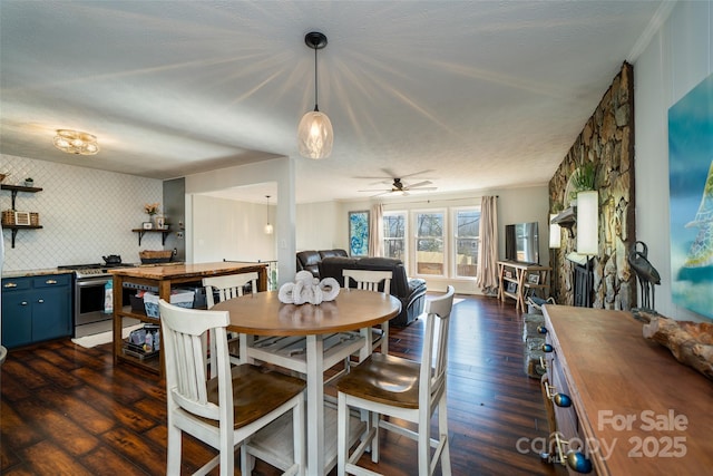 dining room with ceiling fan, dark wood-type flooring, and a textured ceiling