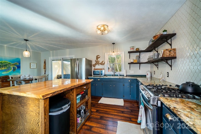 kitchen with sink, blue cabinetry, decorative light fixtures, dark hardwood / wood-style flooring, and stainless steel appliances