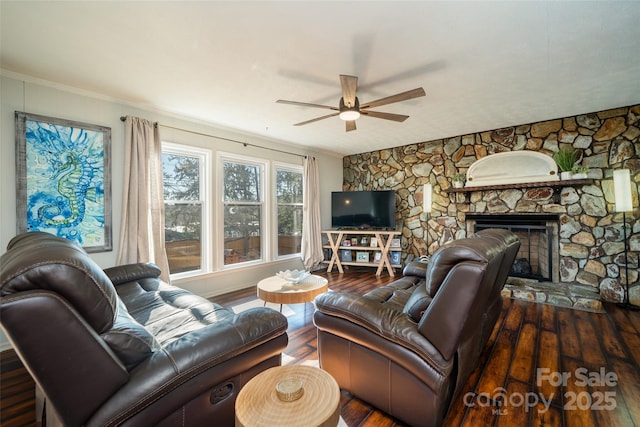 living room featuring ceiling fan, a fireplace, and dark wood-type flooring