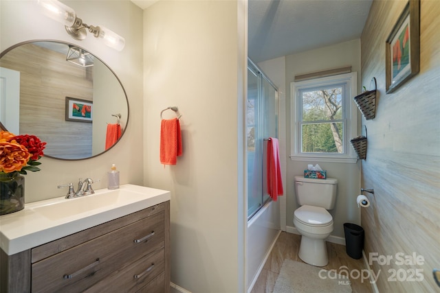 full bathroom featuring combined bath / shower with glass door, wood-type flooring, vanity, and toilet