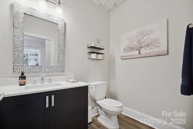 bathroom with hardwood / wood-style floors, vanity, a textured ceiling, and toilet