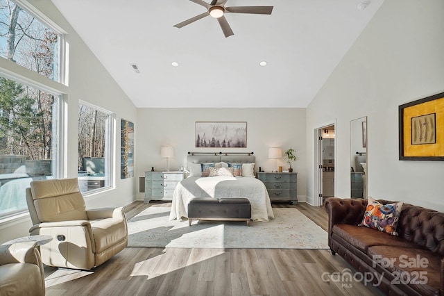 bedroom with ceiling fan, light hardwood / wood-style flooring, and high vaulted ceiling