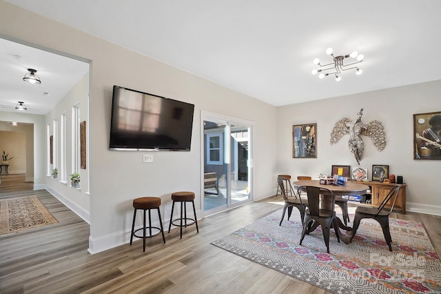 dining room with wood-type flooring and an inviting chandelier