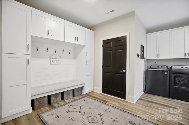 mudroom featuring light hardwood / wood-style floors and washing machine and clothes dryer