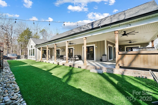 rear view of house featuring ceiling fan, a yard, and a patio