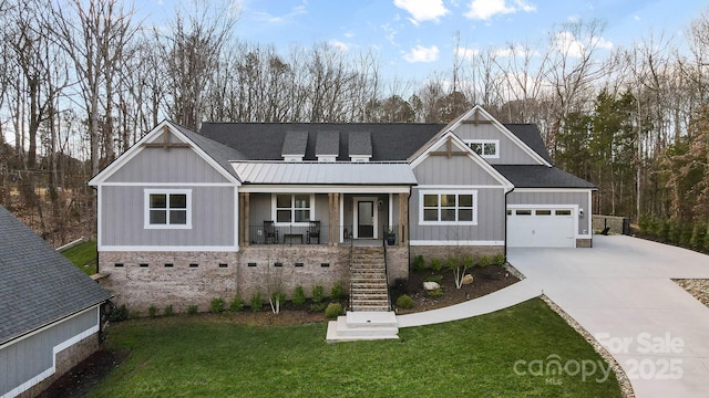 view of front of home with a garage, covered porch, and a front lawn