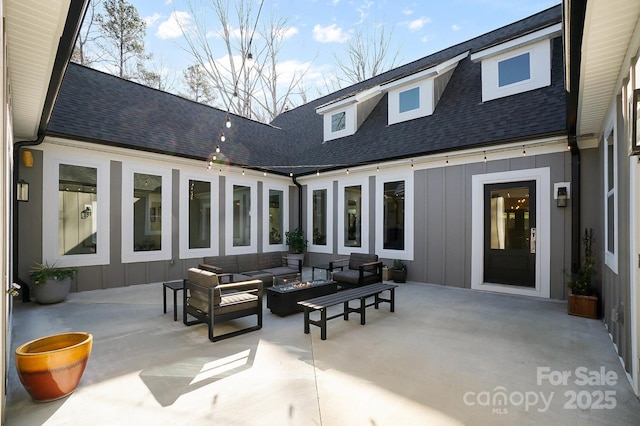 back of property featuring a patio and an outdoor living space with a fire pit