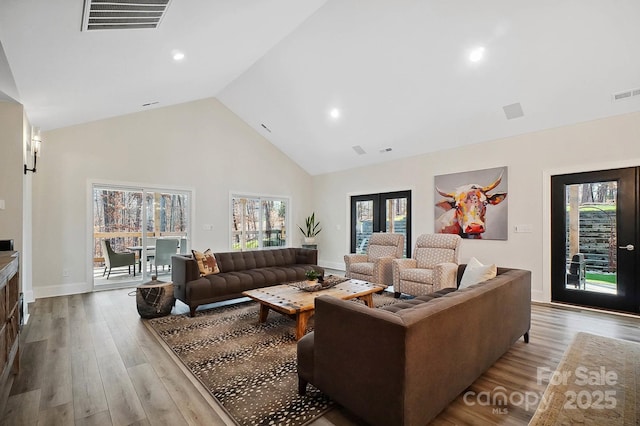 living room with high vaulted ceiling and light hardwood / wood-style floors