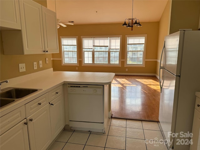 kitchen featuring light tile patterned flooring, kitchen peninsula, pendant lighting, white appliances, and white cabinets