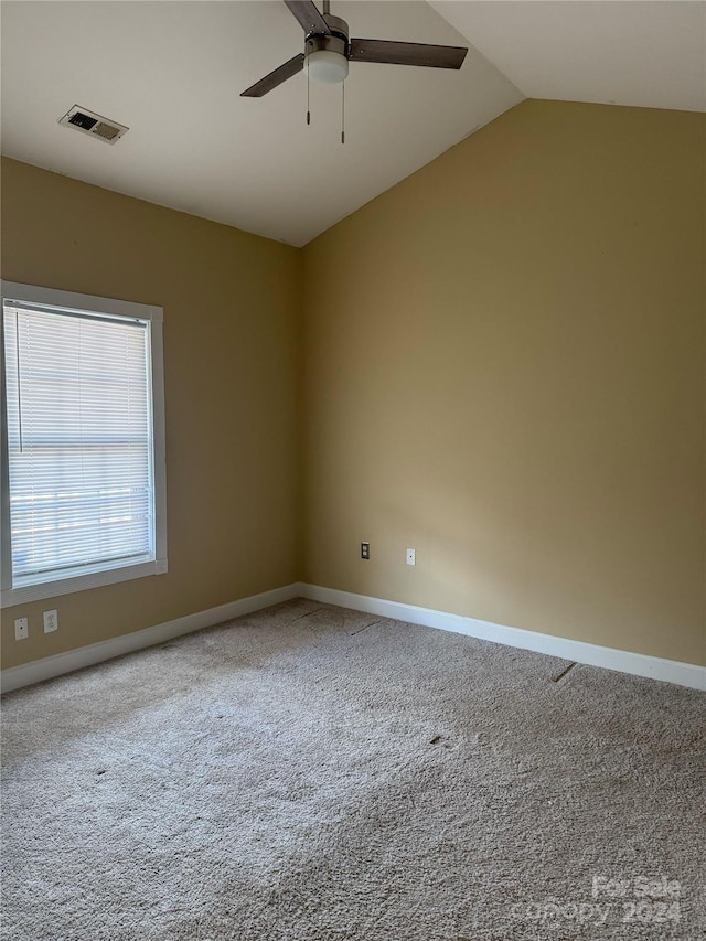 carpeted spare room with vaulted ceiling and ceiling fan