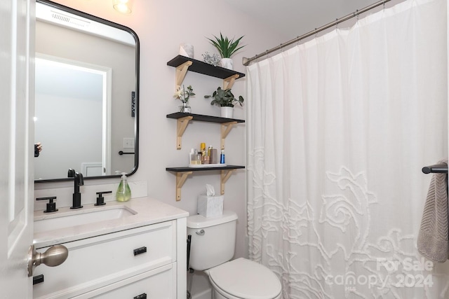 bathroom featuring vanity, toilet, and walk in shower