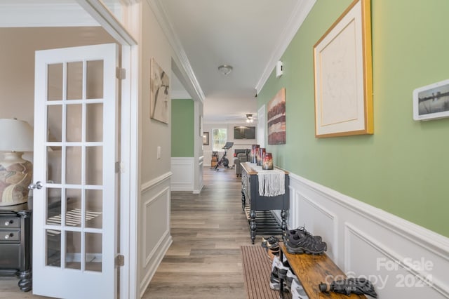 hallway with hardwood / wood-style flooring and ornamental molding