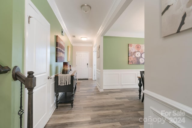 hallway featuring ornamental molding and light hardwood / wood-style flooring