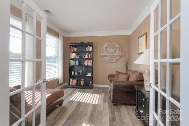 living area featuring french doors, ornamental molding, and hardwood / wood-style floors