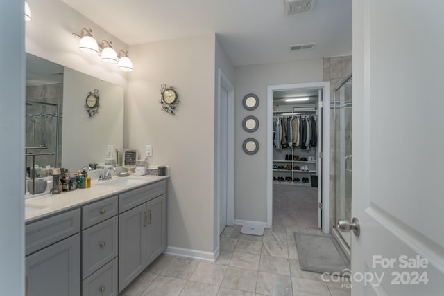 bathroom featuring a shower with door and vanity