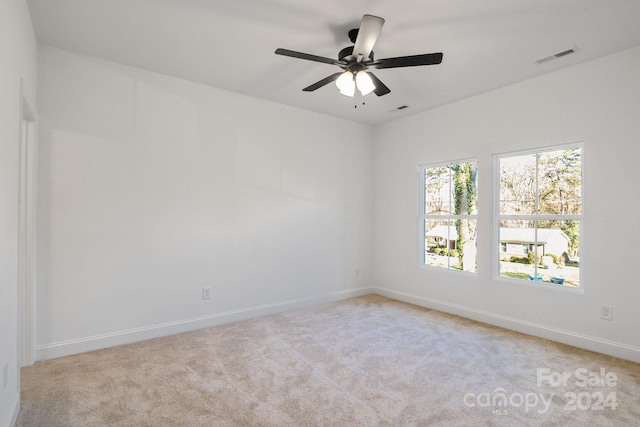 carpeted spare room with ceiling fan