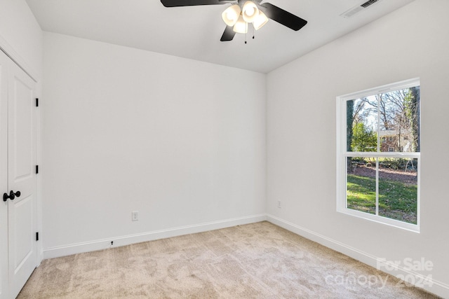 carpeted spare room featuring ceiling fan