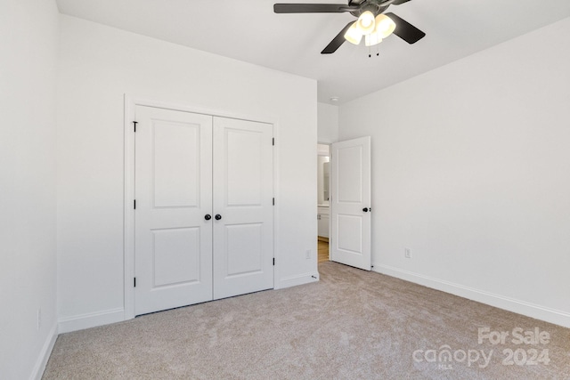 unfurnished bedroom featuring ceiling fan, a closet, and light carpet