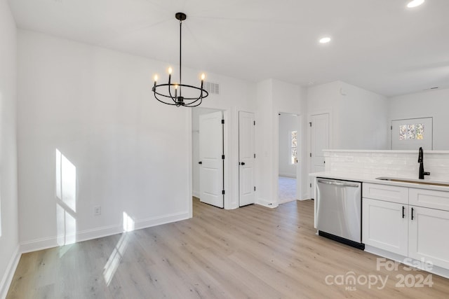 kitchen featuring stainless steel dishwasher, plenty of natural light, pendant lighting, and sink