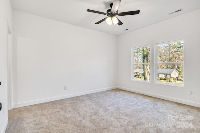 carpeted spare room with ceiling fan