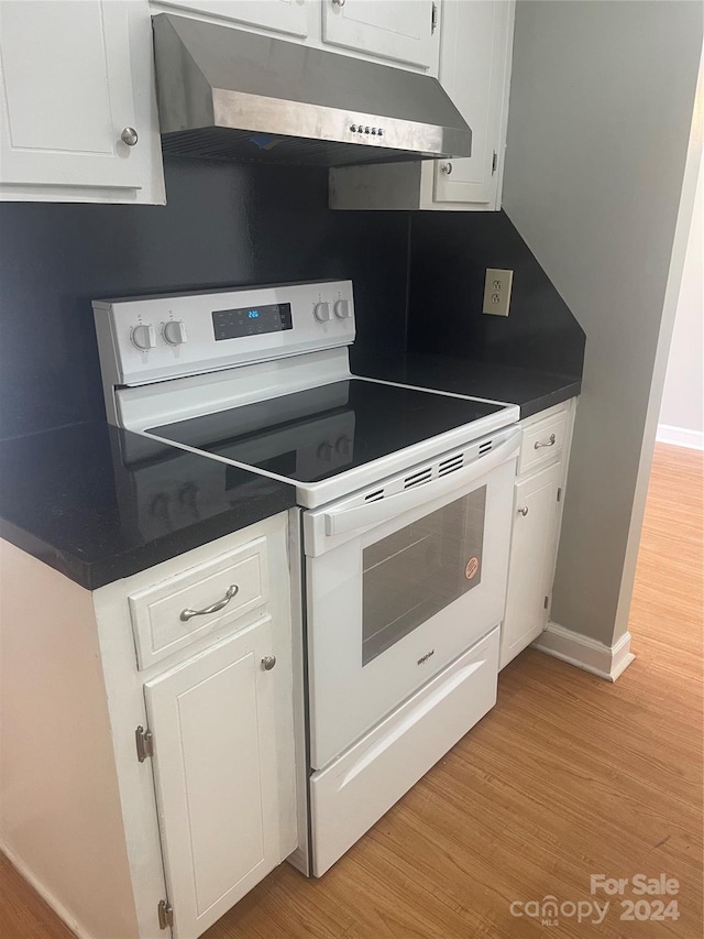 kitchen with white cabinets, light wood-type flooring, and white electric range