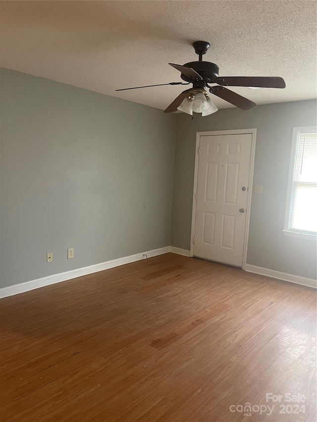 spare room featuring ceiling fan, light hardwood / wood-style floors, and a textured ceiling