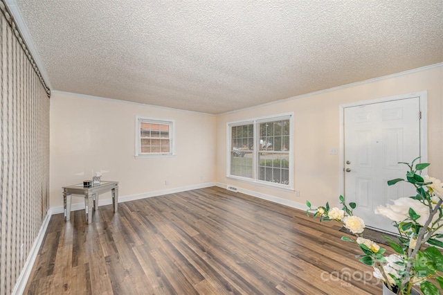 foyer with dark hardwood / wood-style floors, a textured ceiling, and ornamental molding