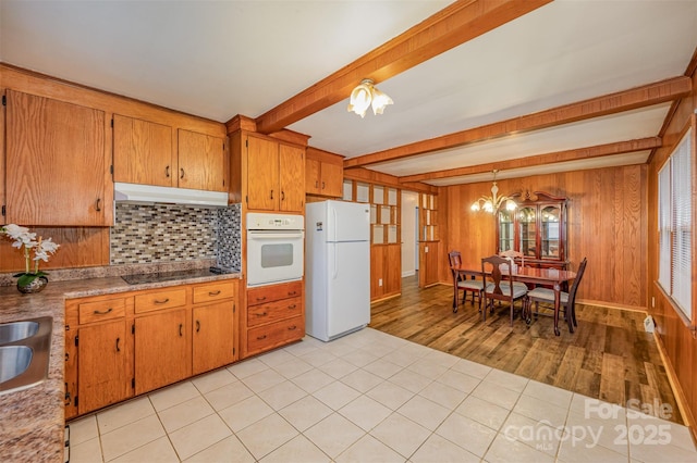 kitchen with beamed ceiling, white appliances, hanging light fixtures, light tile patterned floors, and a chandelier