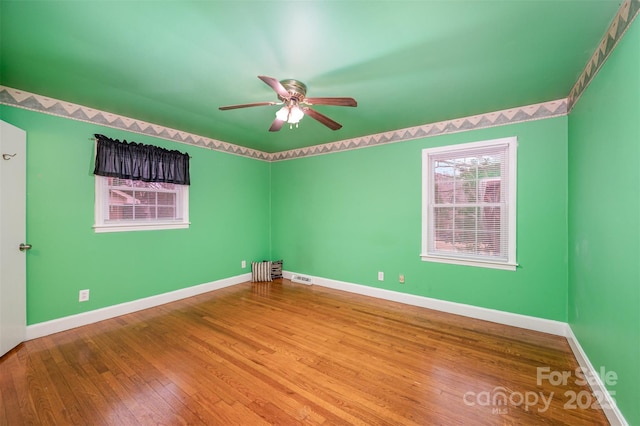 empty room with ceiling fan and hardwood / wood-style flooring