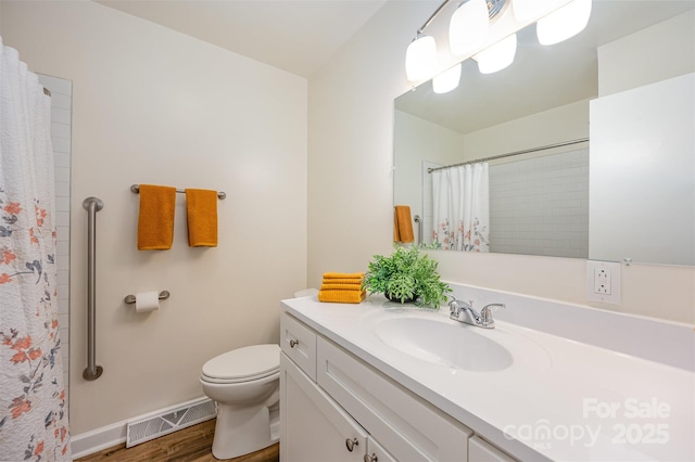 bathroom with toilet, vanity, wood-type flooring, and walk in shower