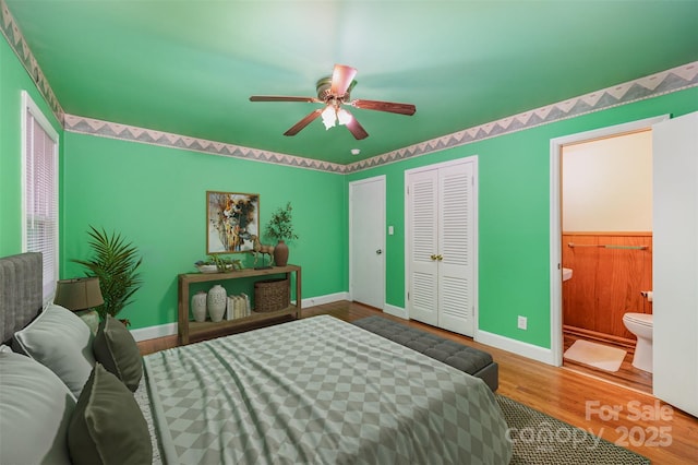 bedroom featuring ceiling fan, ensuite bathroom, and hardwood / wood-style flooring