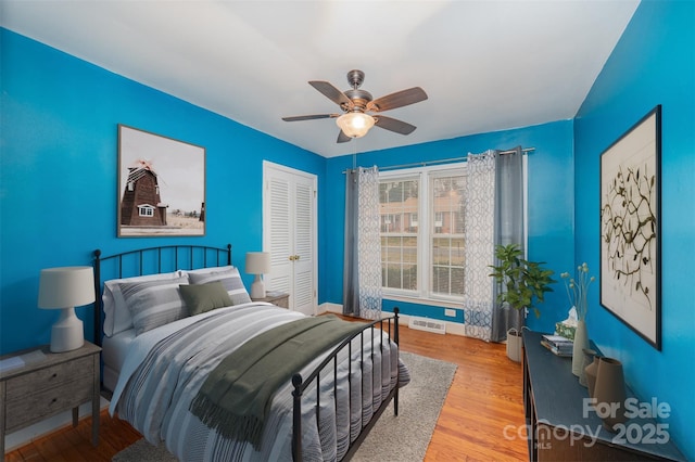 bedroom featuring light wood-type flooring, ceiling fan, and a closet