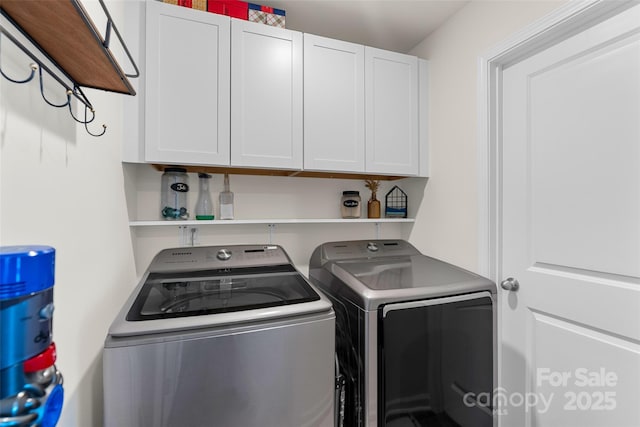 laundry room with washer and dryer and cabinets