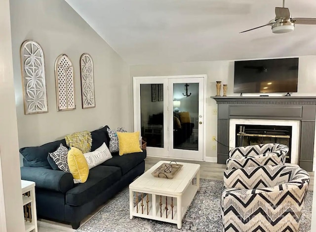 living room featuring ceiling fan, wood-type flooring, and vaulted ceiling