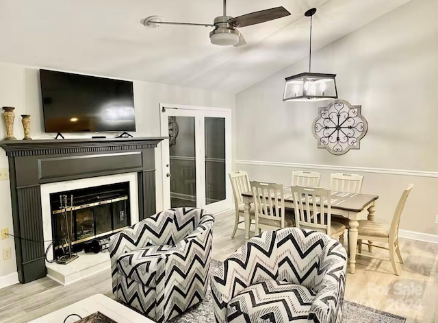 dining room with light hardwood / wood-style floors, ceiling fan, and lofted ceiling