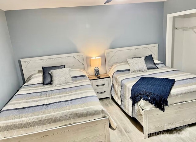 bedroom with ceiling fan, light hardwood / wood-style floors, and a closet