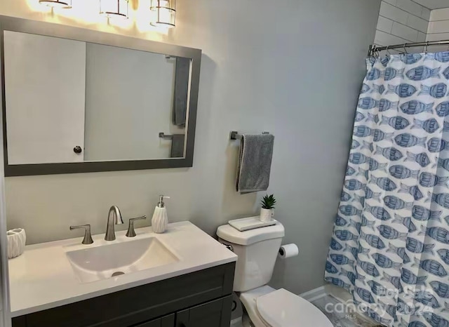 bathroom featuring toilet, vanity, and walk in shower