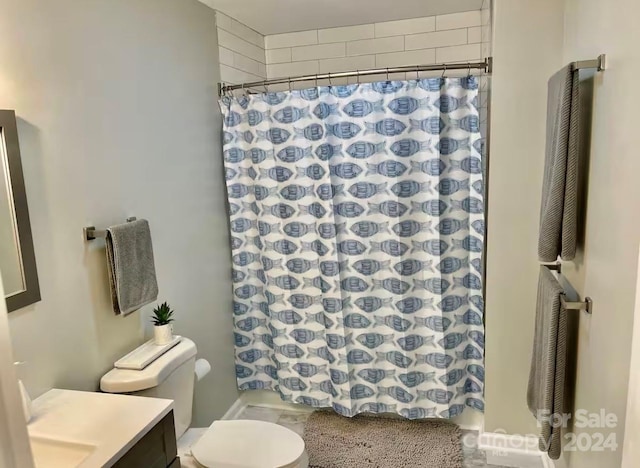 bathroom featuring curtained shower, vanity, and toilet