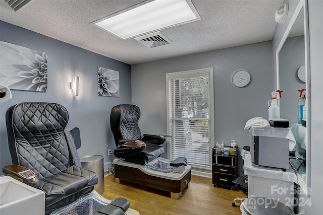 living area with light hardwood / wood-style floors and a textured ceiling