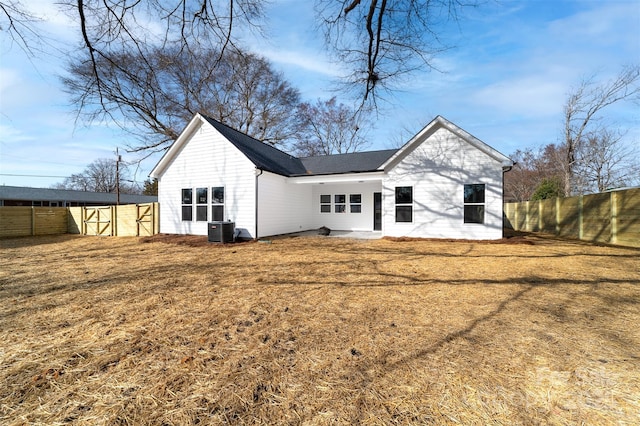 rear view of property featuring central AC, a lawn, and an outdoor structure