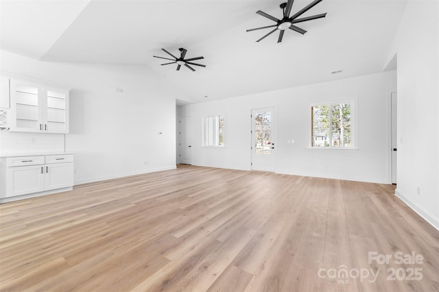 unfurnished living room with lofted ceiling, ceiling fan, and light hardwood / wood-style flooring